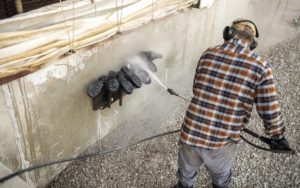 a pig farmer sprays down boots as he thinks about how to hire a freelance writer for his ag content